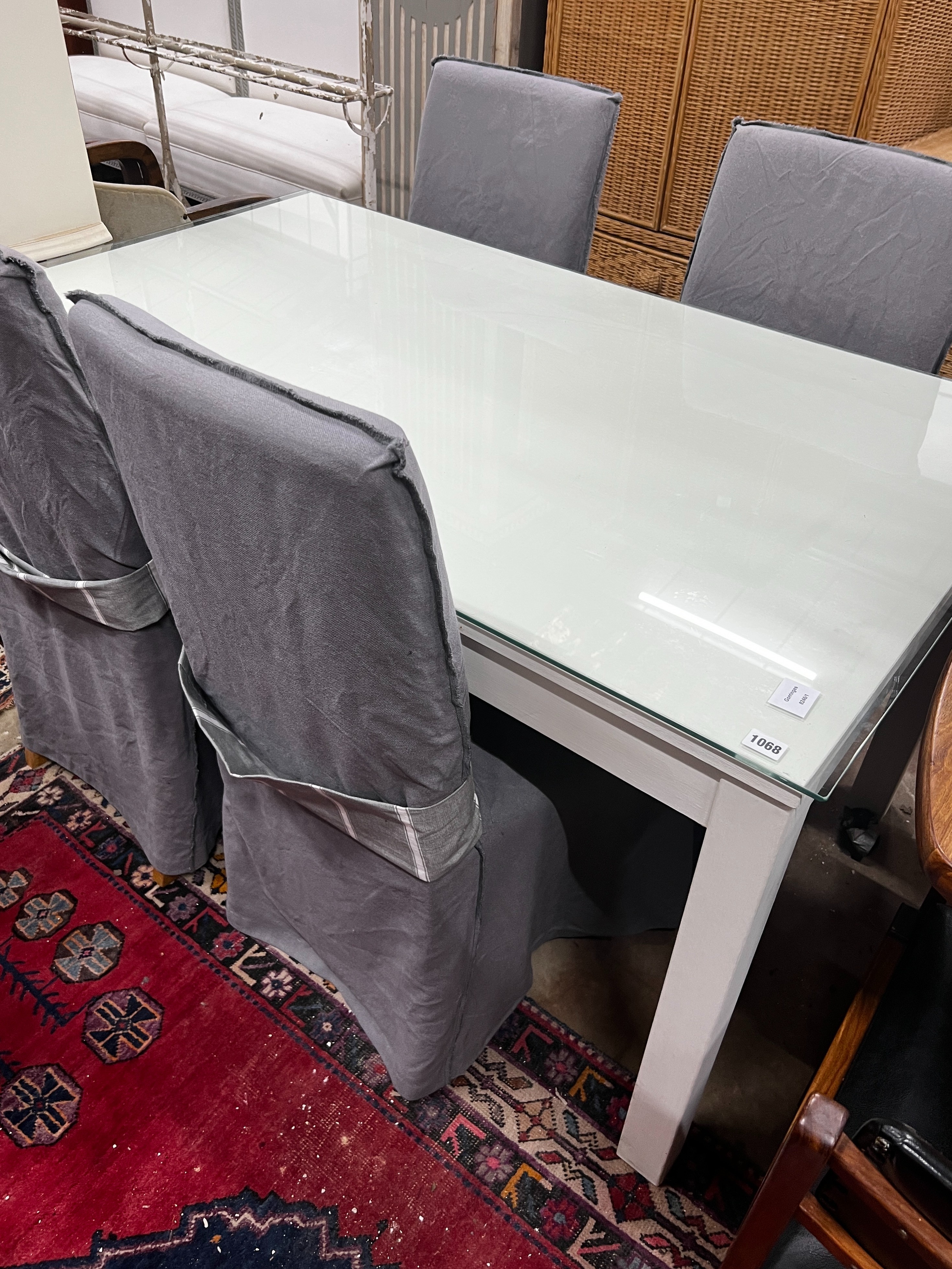 A contemporary rectangular dining table, length 140cm, width 84cm, height 75cm and four linen covered chairs *Please note the sale commences at 9am.